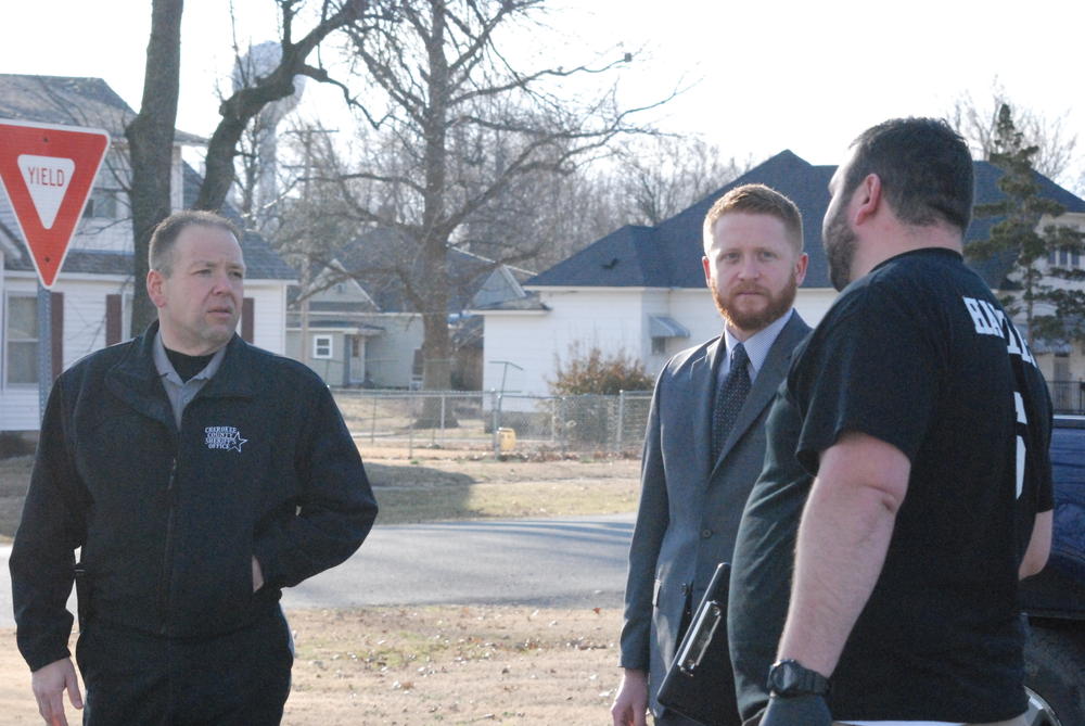 Sheriff David Groves and County Attorney Jake Conard get briefed from Sgt. Investigator Beau Hamlin