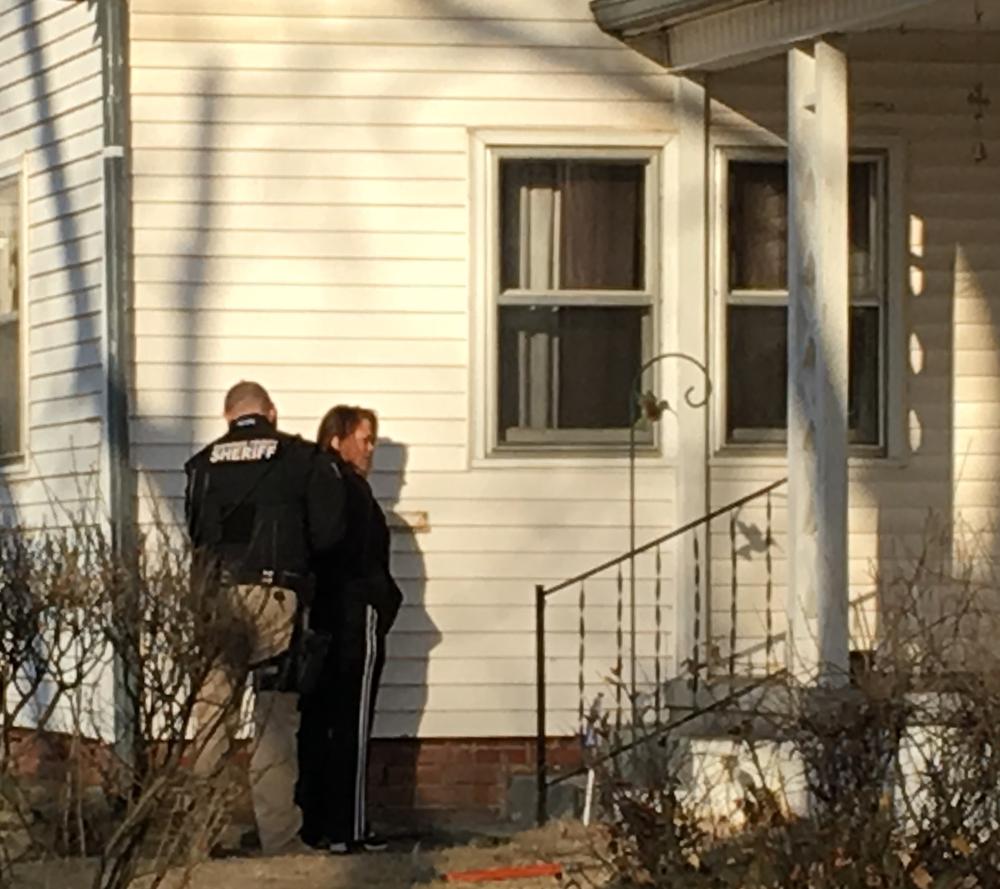 Officer and woman standing outside residence