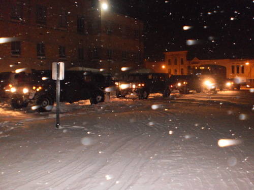 Military vehicles parked on the street at night