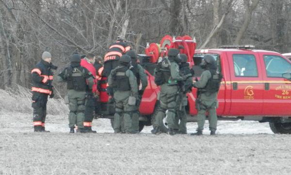 Many officers standing by and in a red truck