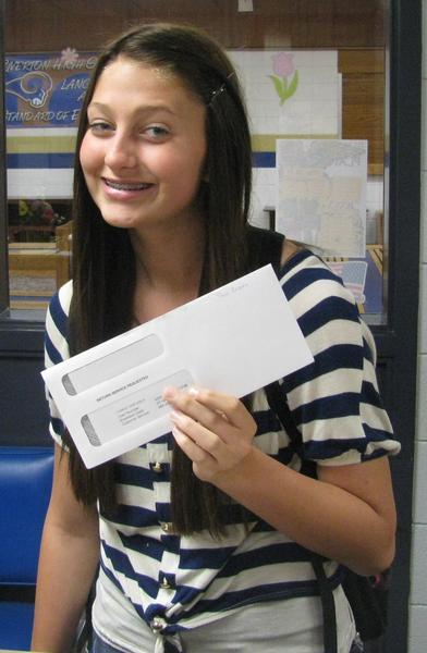 Brunette female student recipient holding up her award envelope