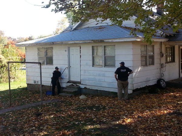 two officers standing outside a home's front door