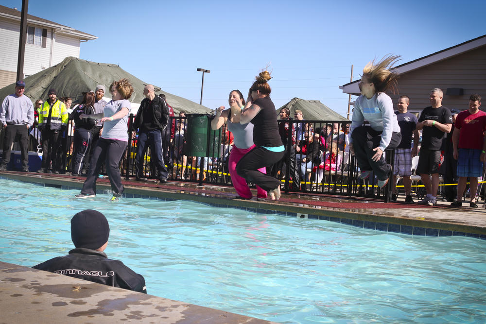 Female officers jumping into a pool