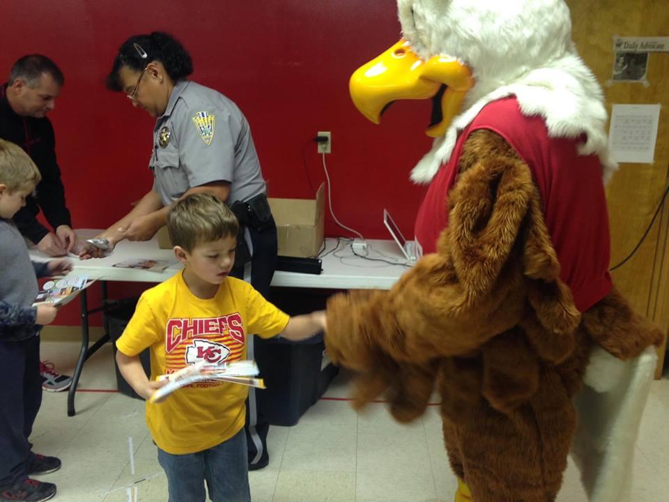 Eddie Eagle shaking hands with a student