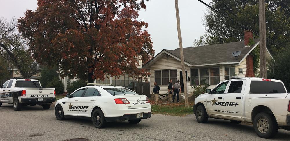 three police vehicles parked outside residence, with 3 officers going into the home