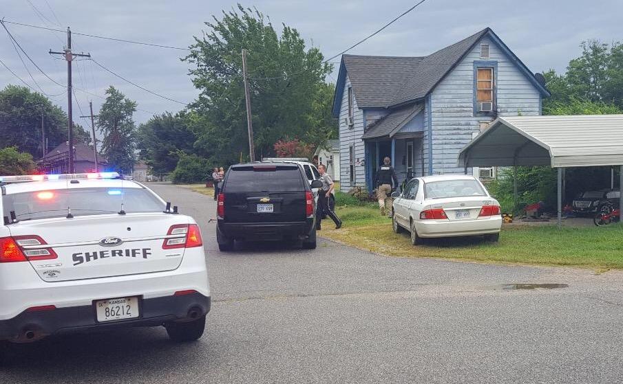 2 police vehicles outside residence with officers running