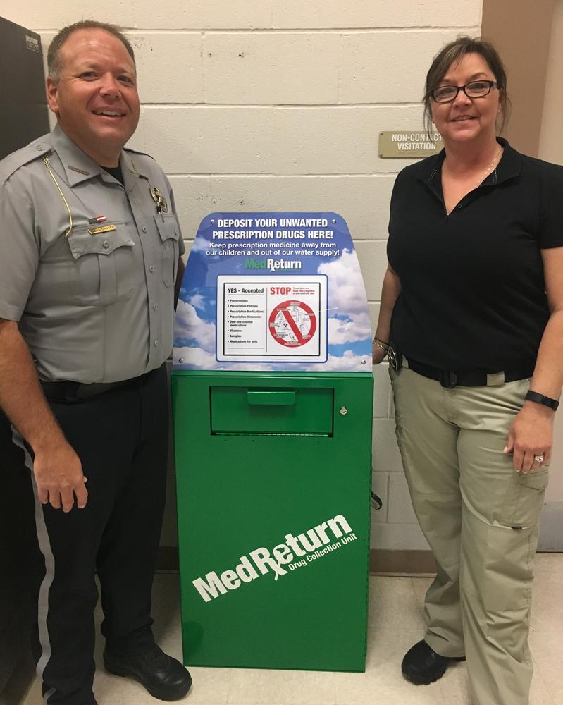 Sheriff David Groves and Captain Michelle Tippie standing by Drug Drop Box