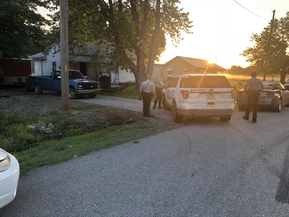 police vehicles parked outside residence with blue pickup truck in drivewy