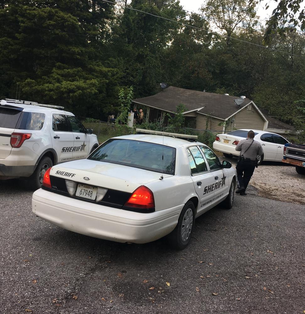 2 police vehicles outside residence, with one officer walking toward residence